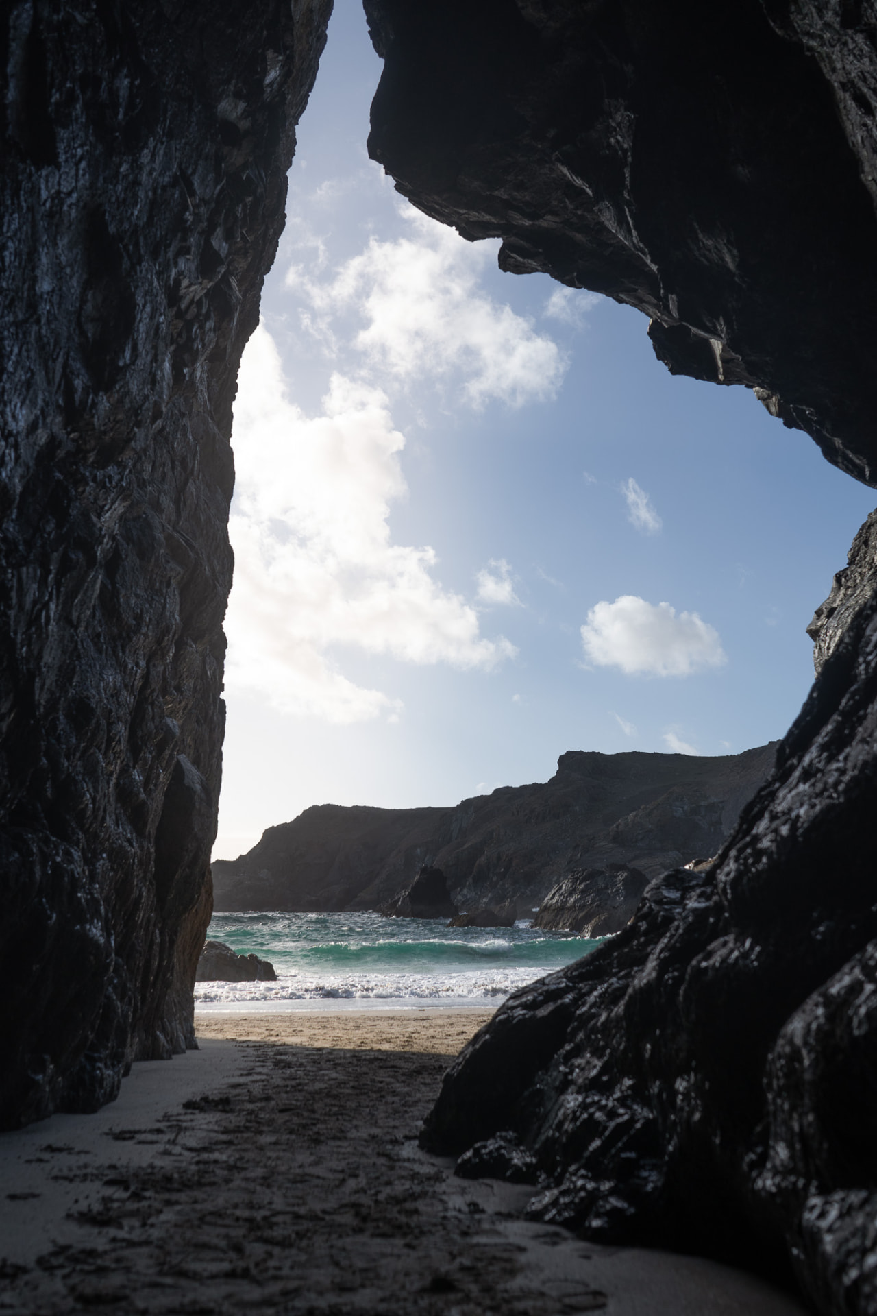 Looking out through a rock arch towards the beach at Kynance Cove