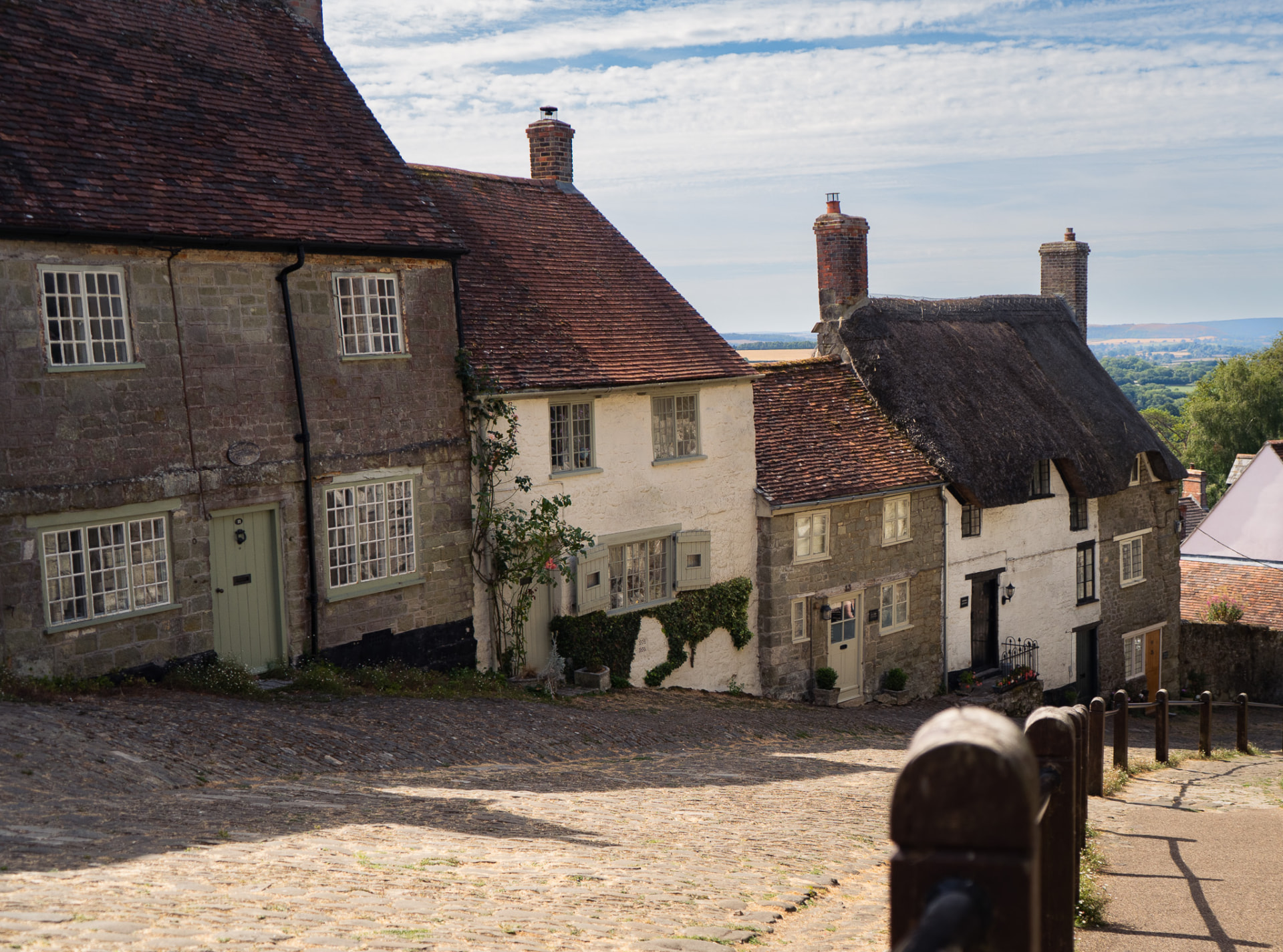 Cobbled Gold Hill in Shaftesbury lined with thatched and stone cottages.