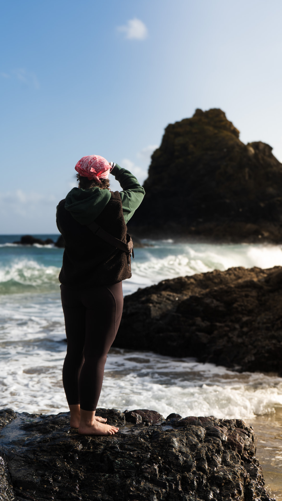 Standing on the rocks at Kynance Cove, surf rolling in behind