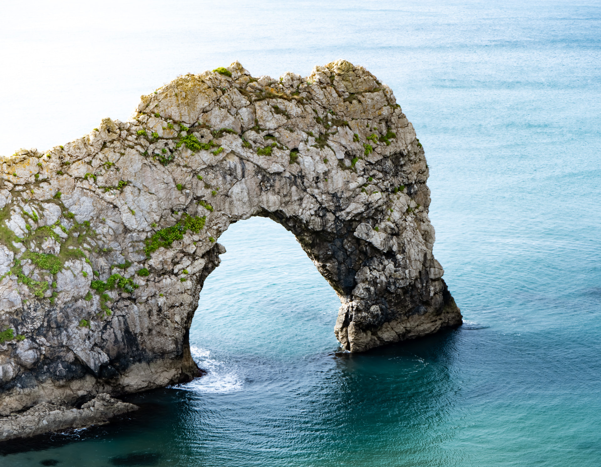 Durdle Door, a limestone sea arch reaching into clear turquoise water on the Dorset coast